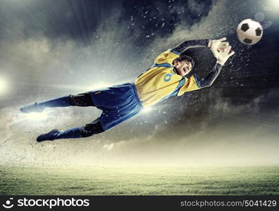 Goalkeeper catches the ball. Goalkeeper catches the ball . At the stadium, in the spotlight.