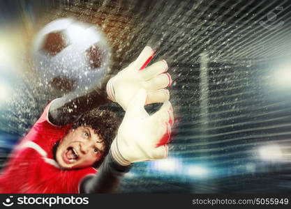 Goalkeeper catches the ball. Goalkeeper catches the ball . At the stadium, in the spotlight.