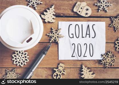 Goals for 2020 word on paper with pen and coffee cup on wooden table. Business concept.