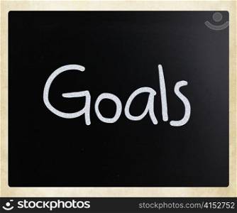 ""Goals" handwritten with white chalk on a blackboard"