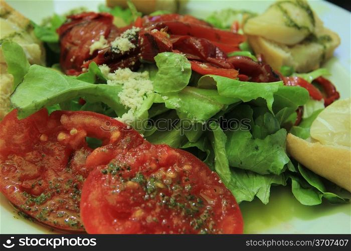 Goat cheese tomato salad with condiments, close up