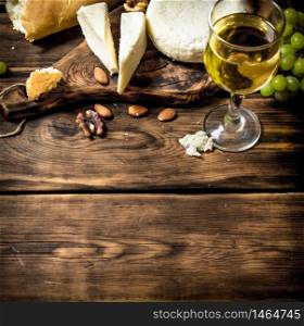 Goat cheese with white wine and nuts. On a wooden table.. Goat cheese with white wine and nuts.