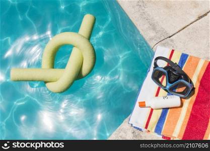 goggles with lotion towel near pool