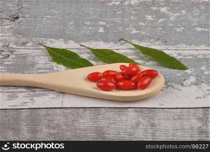 Gojiberry on wooden spoon and timber