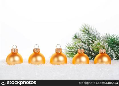 Gold balls in snow on white background. Christmas concept