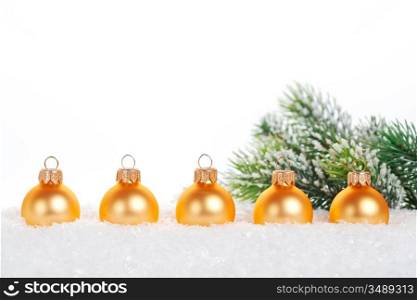 Gold balls in snow on white background. Christmas concept