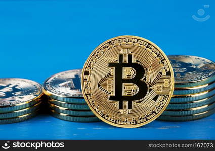 Gold bitcoin against the background of increasing stacks of bitcoins. Blue background. The concept of virtual money and business.. Gold bitcoin against the background of increasing stacks of bitc