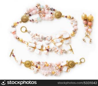 gold bracelet and necklace with pearls and pink quartz and earringsat white background