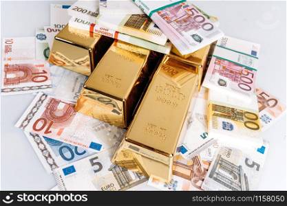 Gold bullions at euro banknotes closeup background. Gold bars lie on Euro banknotes