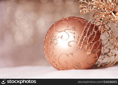 Gold Christmas bable on defocused golden lights. Shallow DOF.