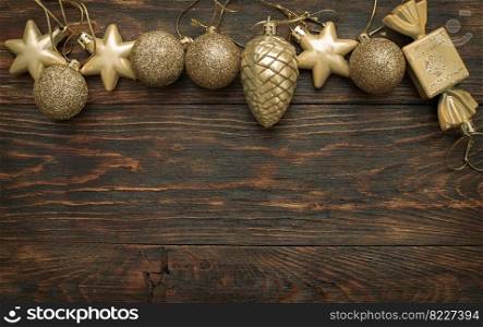 Gold Christmas balls and toys on a wooden background.. Gold Christmas balls and toys on a wooden background