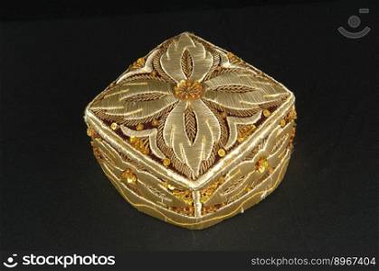 gold colored traditional asian skullcap cap on a dark background. traditional asian skullcap