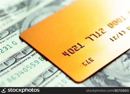 Gold credit card on dollar notes. Shalow DOF!