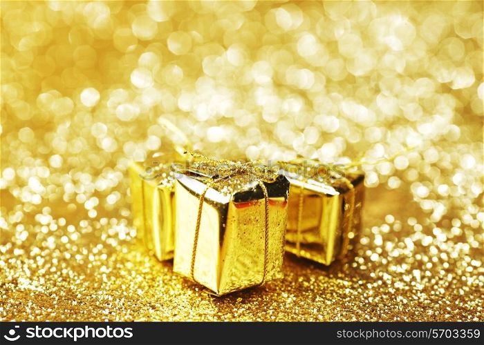Gold decorative boxes with holiday gifts on abstract gold background