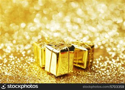 Gold decorative boxes with holiday gifts on abstract gold background