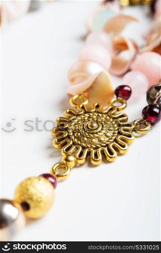 gold detail of bijouterie with semiprecious at white background