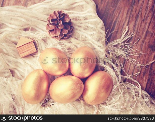 Gold easter eggs and decorated on wood background with retro filter effect