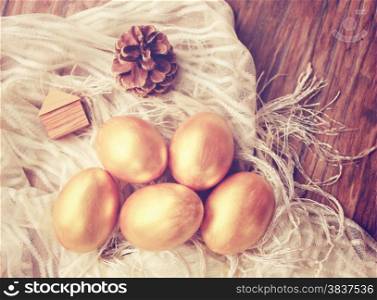 Gold easter eggs and decorated on wood background with retro filter effect