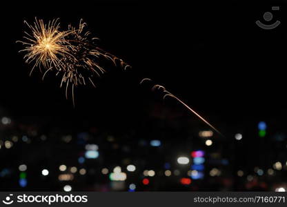 Gold fireworks with blurred bokeh city light background in New Year and copy space. Abstract background holiday.