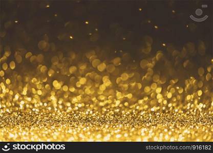 Gold glitter sparkle lights background. Defocused glitter abstract twinkly light and shiny stars. Christmas and New year party concept background. Closeup stardust.