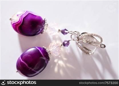 gold jewerly earrings with agat and fluorite semiprecious at white background