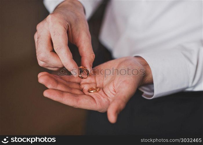 Gold rings of spouses in the hands of men.. Wedding rings in mens hands 1146.. Wedding rings in mens hands 1146.
