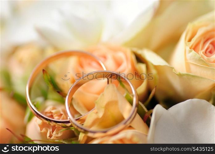 Gold rings on a bouquet of roses. Shallow DOF, selective focus. Weddinf postcard&#xA;