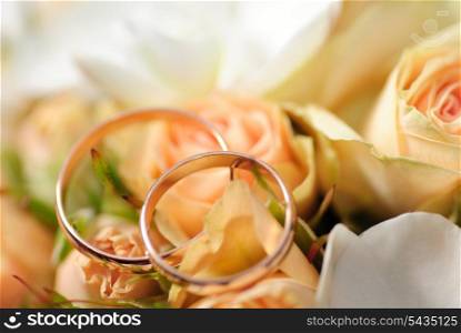 Gold rings on a bouquet of roses. Shallow DOF, selective focus. Weddinf postcard&#xA;