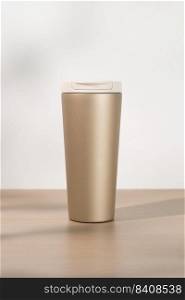 Gold stainless steel tumbler size 20 ounce on wooden table.