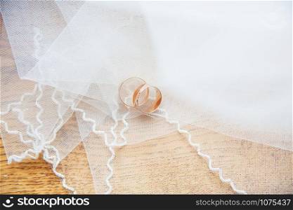 Gold wedding rings on a white veil. Gold wedding rings on white veil