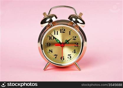 golden alarm clock on a color background, theme time
