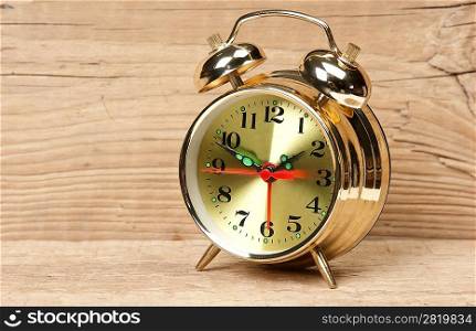 golden alarm clock on a wooden table