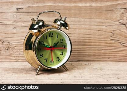 golden alarm clock on a wooden table
