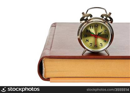 golden alarm clock on the book isolated on a white background