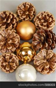Golden and pearly baubles and pine cones as decoration for Christmas