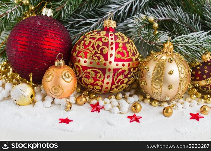 golden and red christmas ball and evegreen fir tree in snow . golden christmas bow and evegreen tree