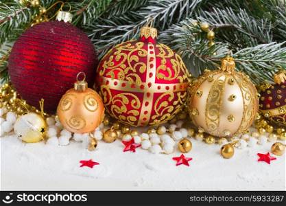 golden and red christmas ball and evegreen fir tree in snow . golden christmas bow and evegreen tree