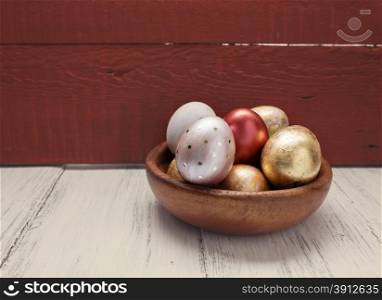 Golden and red Easter eggs in wooden plate