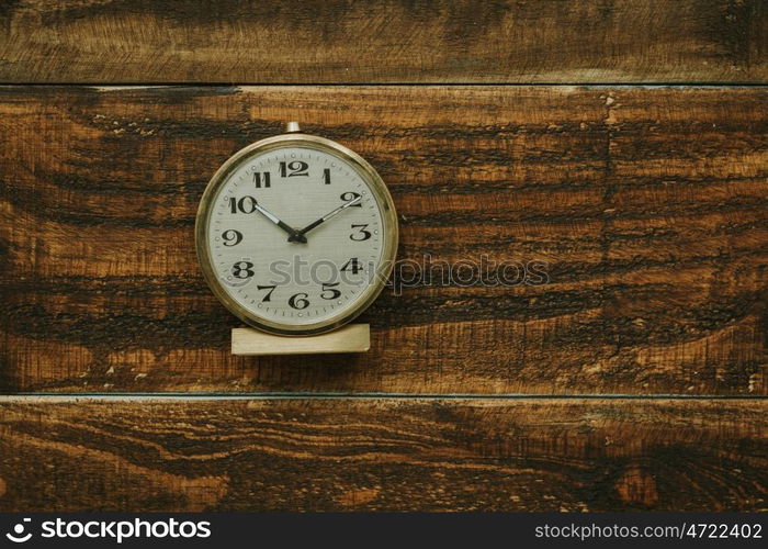 Golden antique alarm clock on a rustic wooden background