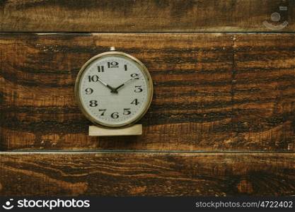 Golden antique alarm clock on a rustic wooden background