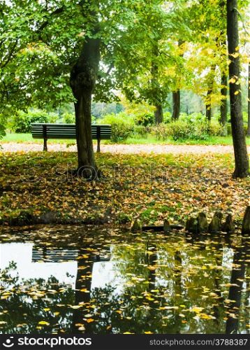 golden autumn park bench. Golden Autumn bench in the park is reflected in water