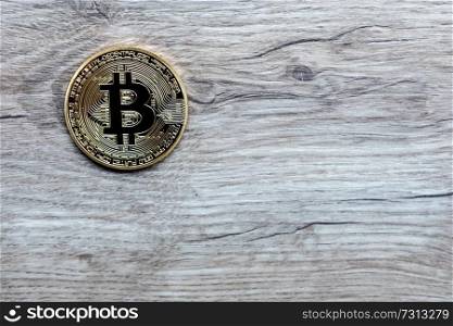 Golden Bitcoin Coin Close Up with a wooden background