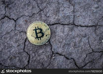 Golden Bitcoin Coin on dry cracked ground background. Financial Crisis concept Bitcoin cryptocurrency.