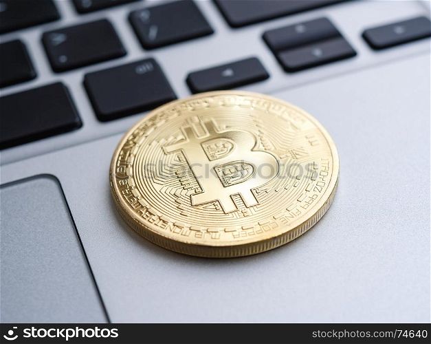 Golden bitcoin coin on laptop, shallow depth of field