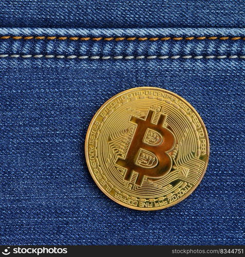 Golden Bitcoin lies on a blue jeans fabric. New virtual money. New crypto currency in the form of the coins