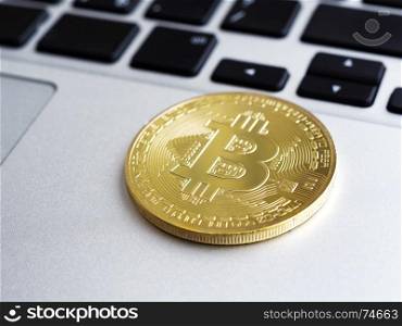 Golden bitcoin on laptop, shallow depth of field. Golden bitcoin on laptop