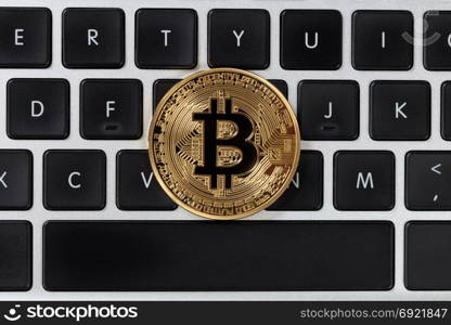 Golden Bitcoin on top computer keyboard