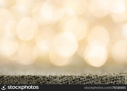 Golden bokeh background with wooden table close up. Golden bokeh background