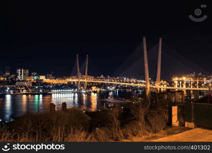 Golden bridge in Vladivostok at night.. Night view of the city of Vladivostok. Vladivostok, Russia.