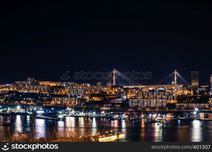 Golden bridge in Vladivostok at night.. Night view of the city of Vladivostok. Vladivostok, Russia.